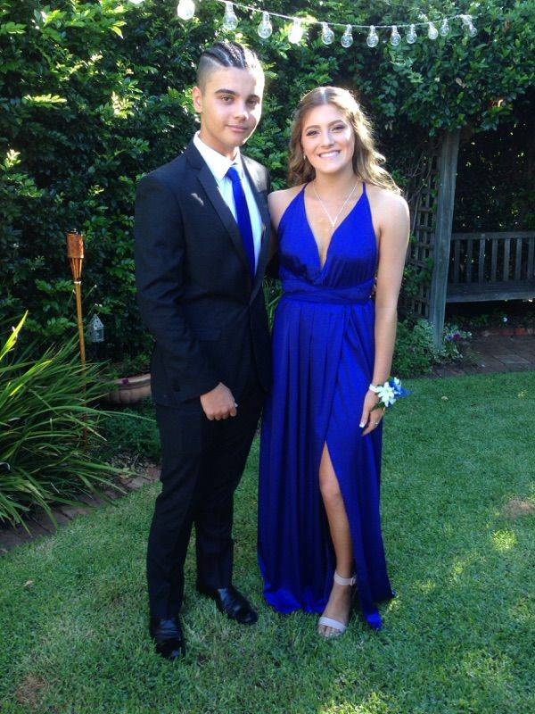 A young couple dressed in Royal Blue with a blue and white corsage.