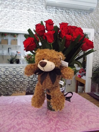 Bouquet of roses in vase with teddy bear