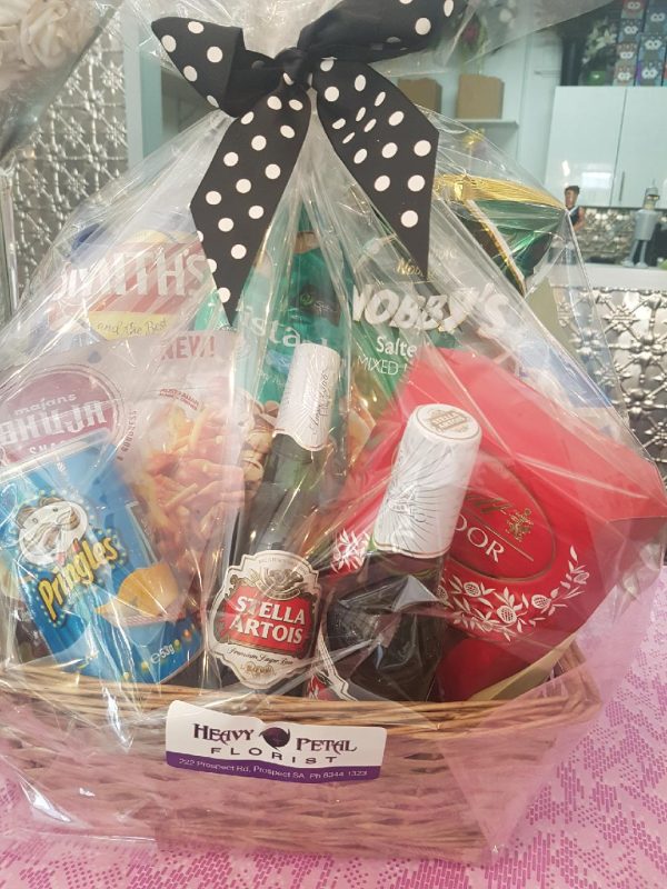 Hamper of snacks and drinks in basket, wrapped in cellophane