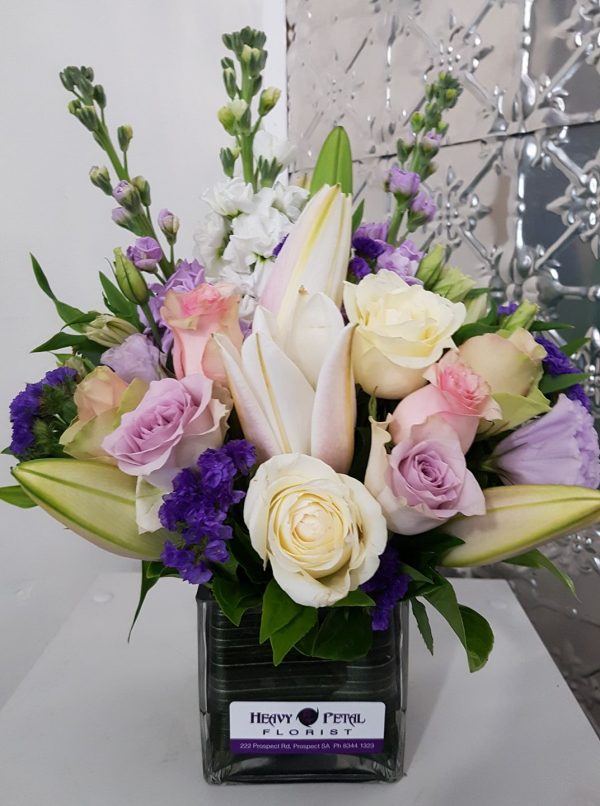 An arrangement of pastel flowers in a glass vase.