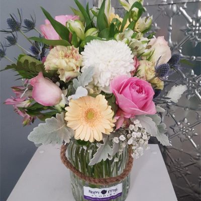 A bouquet of flowers in a rustic vase.