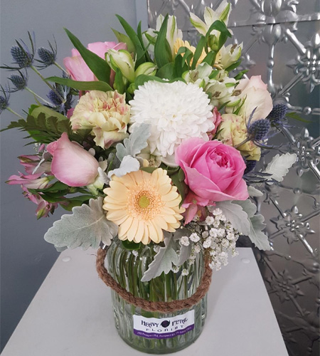 A bouquet of flowers in a rustic vase.
