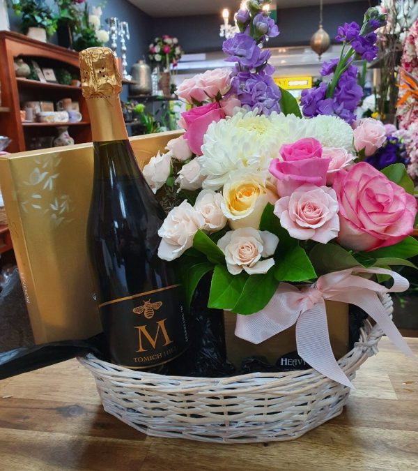 A Floral hamper basket with wine and chocolates
